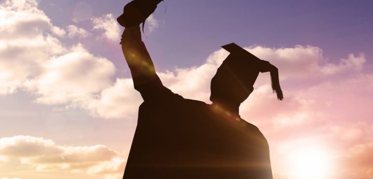 Silhouette of graduate against sun shining