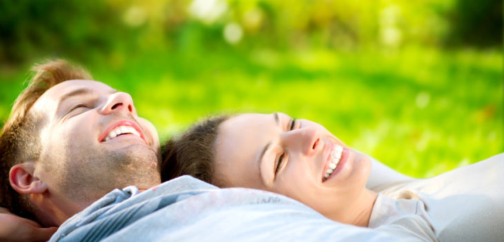 Park. Young Couple Lying on Grass Outdoor