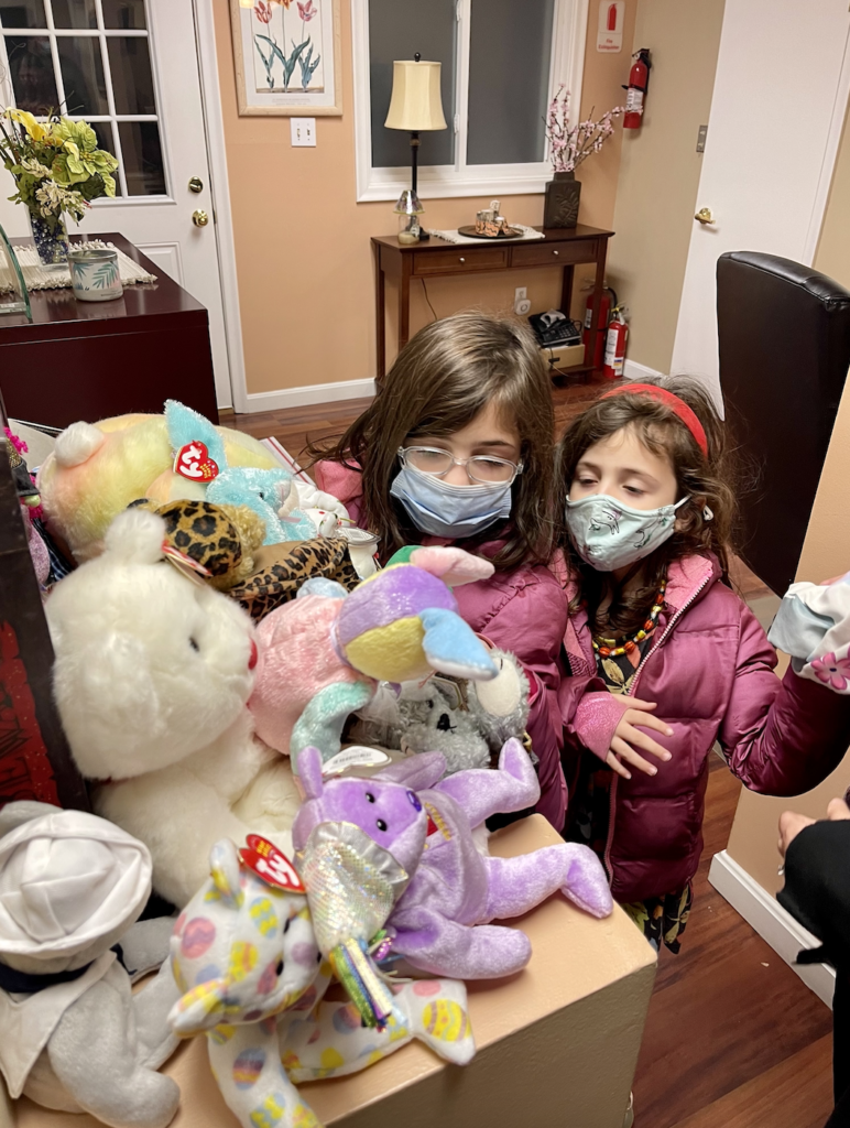 Two children picking out prize beanie babies to take with them after donating candy.