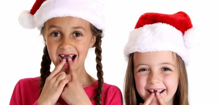 girls wearing santa hats missing their two front teeth